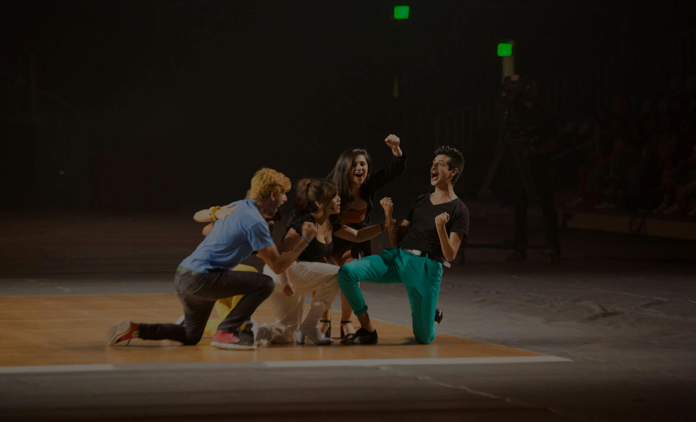 Four performers on stage dancing and singing.