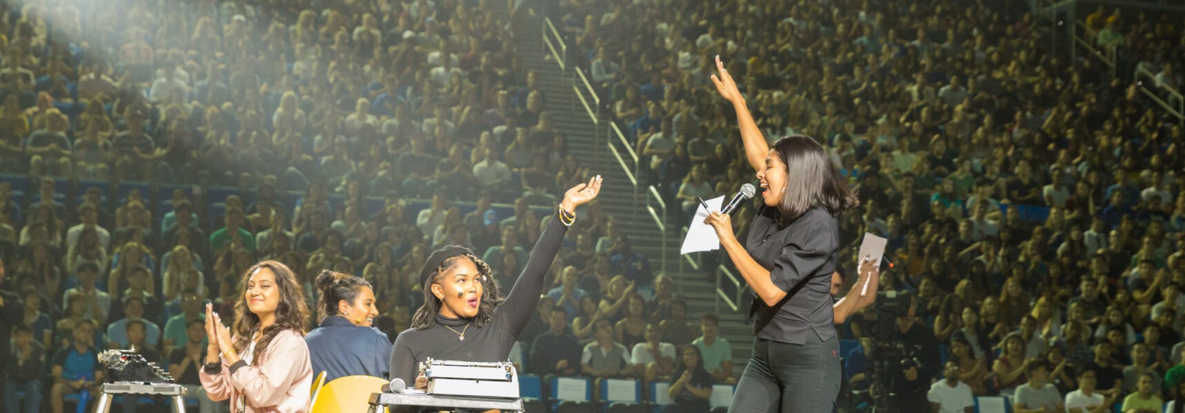 A woman on stage speaking to a crowd.