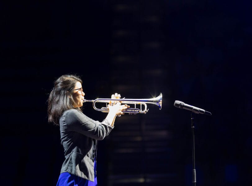 A woman playing the trumpet on stage.