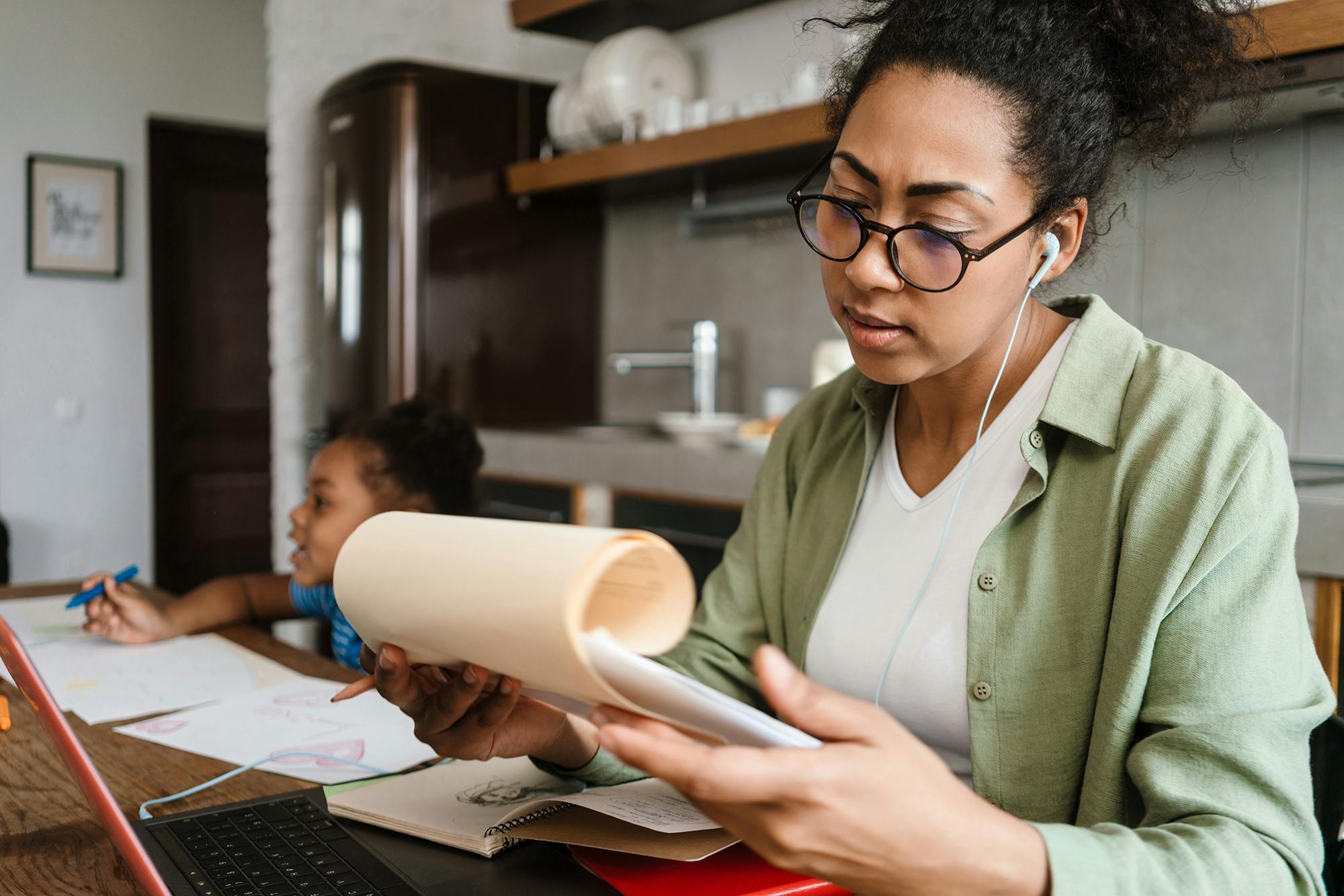 Woman working from home with child in background