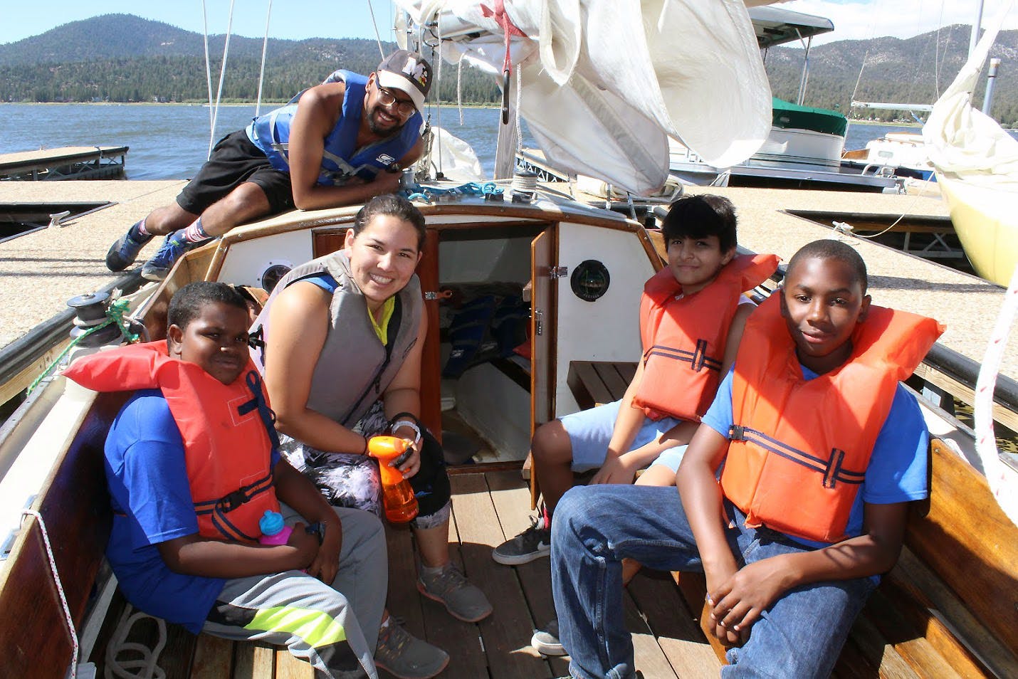 UniCamp counselors Hugo Vega and Lauren Phinney enjoy sailing with young campers on Big Bear Lake. 