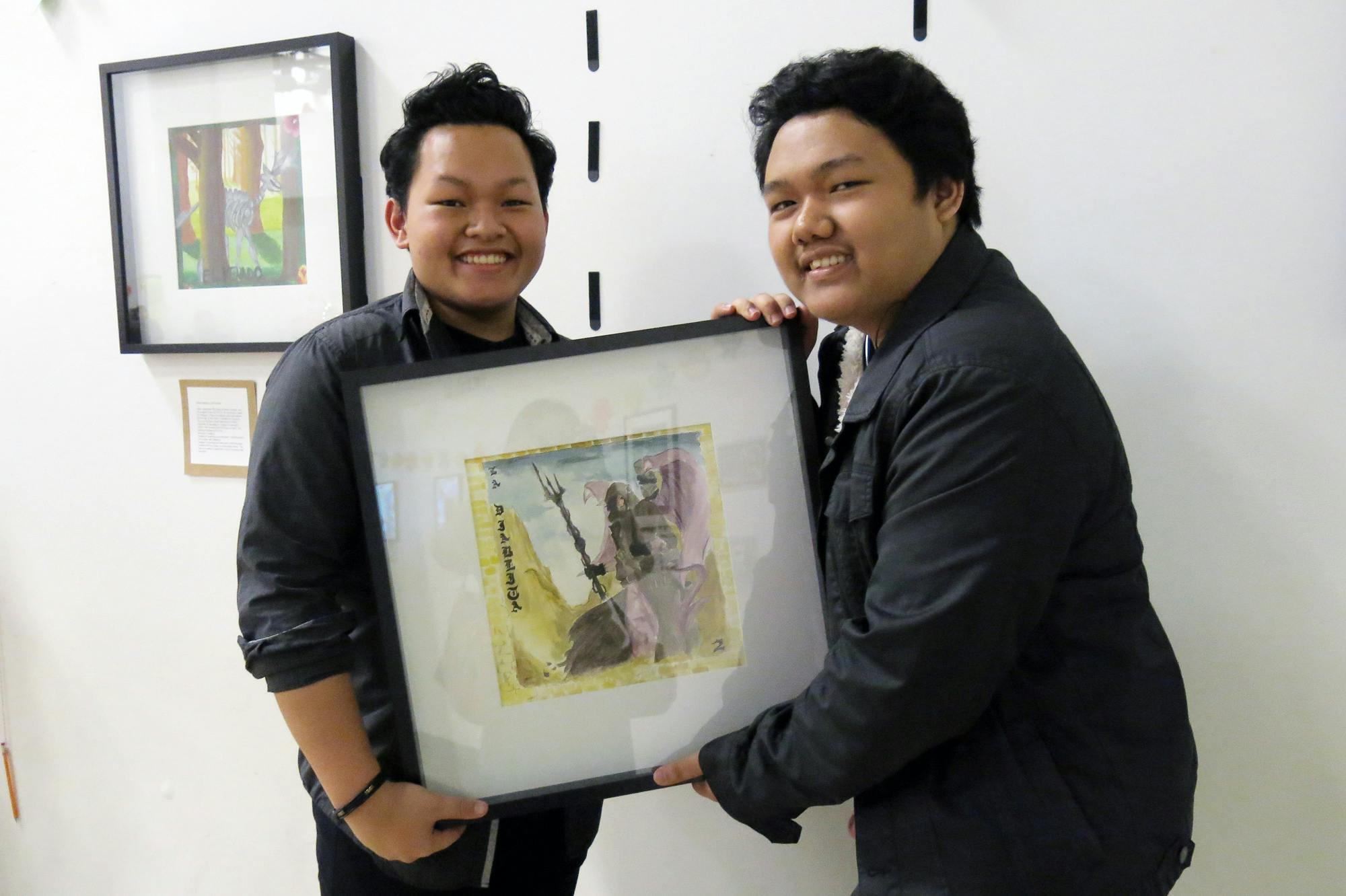 Jeremiah Borbe, a junior at UCLA Community School, helped his brother Joshua, a senior, to display his artwork at the 4th Art Auction.