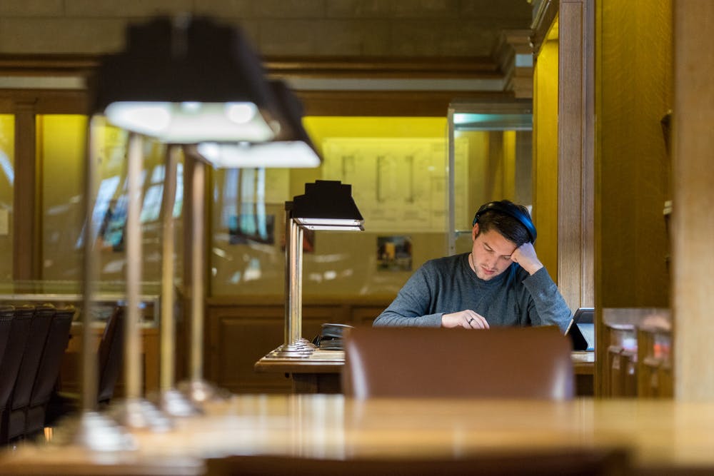 Male student studying in college library.