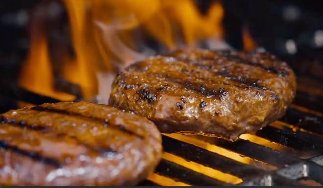 Two Beyond Burger patties on a grill. 