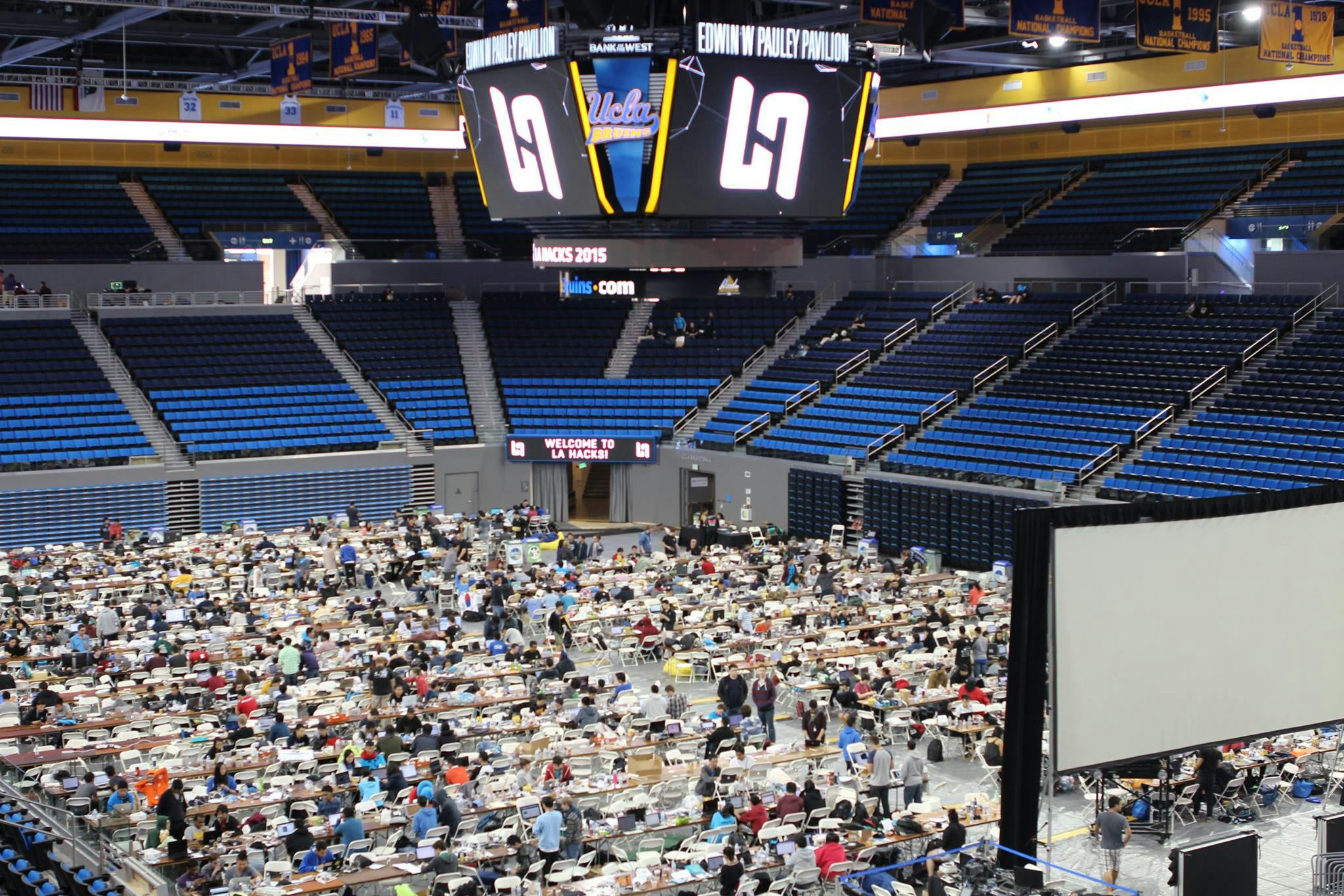 Stadium is filled with rows of tables and students using computers.