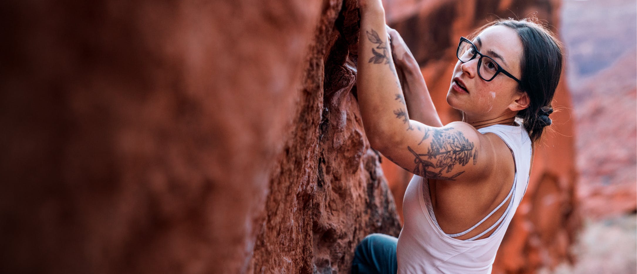 Woman rock climbing wearing ROKA eyeglasses