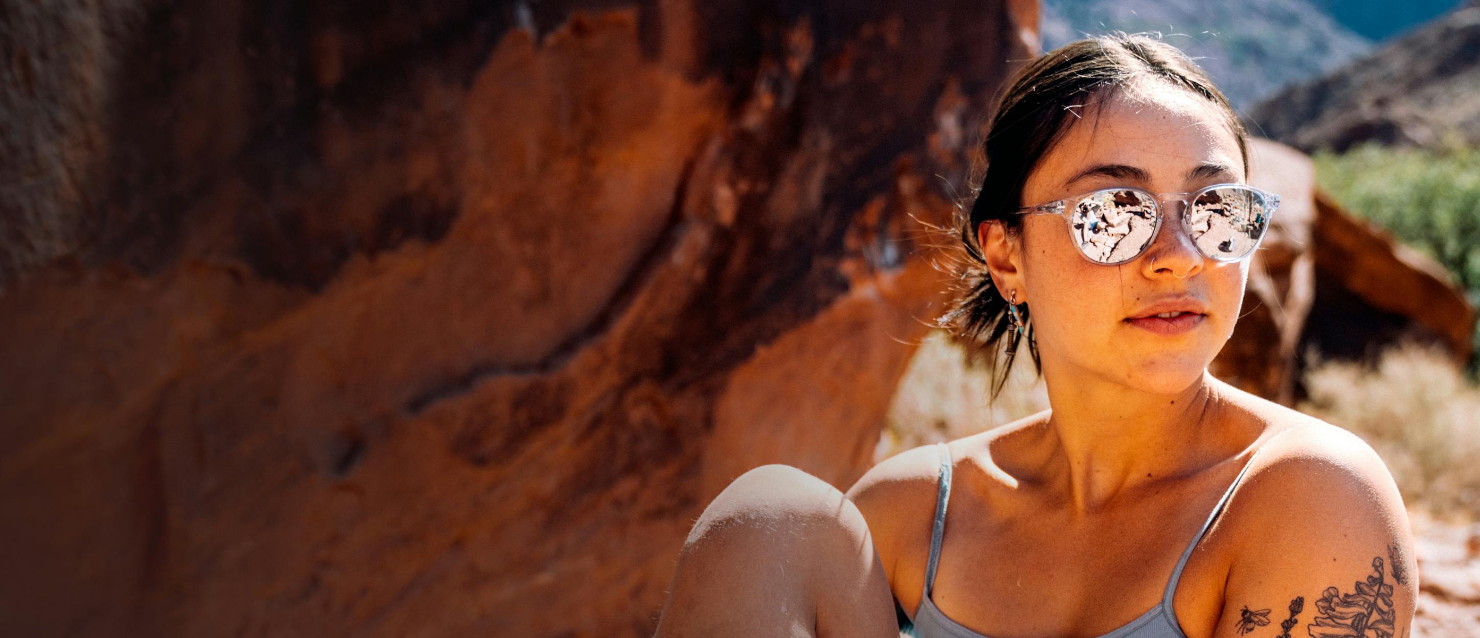 Woman rock climbing wearing ROKA sunglasses