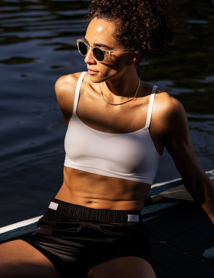 Woman paddleboarding wearing ROKA sunglasses