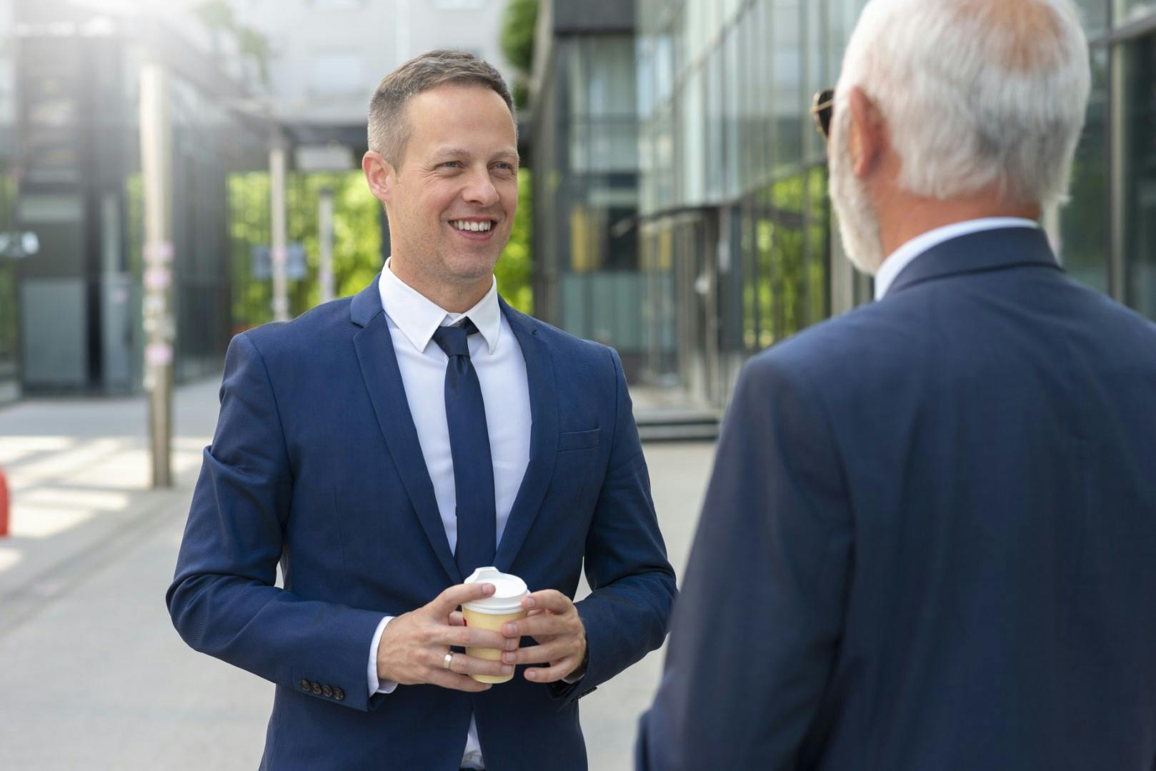 2 men in suits talking outside offices