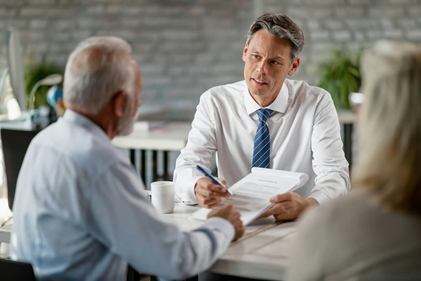business man handing contract and pen to another person