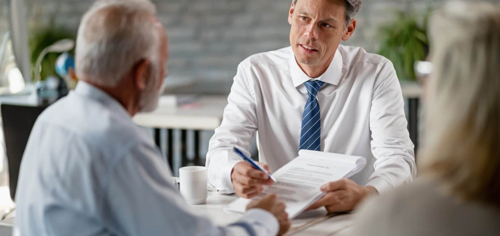 business man handing contract and pen to another person
