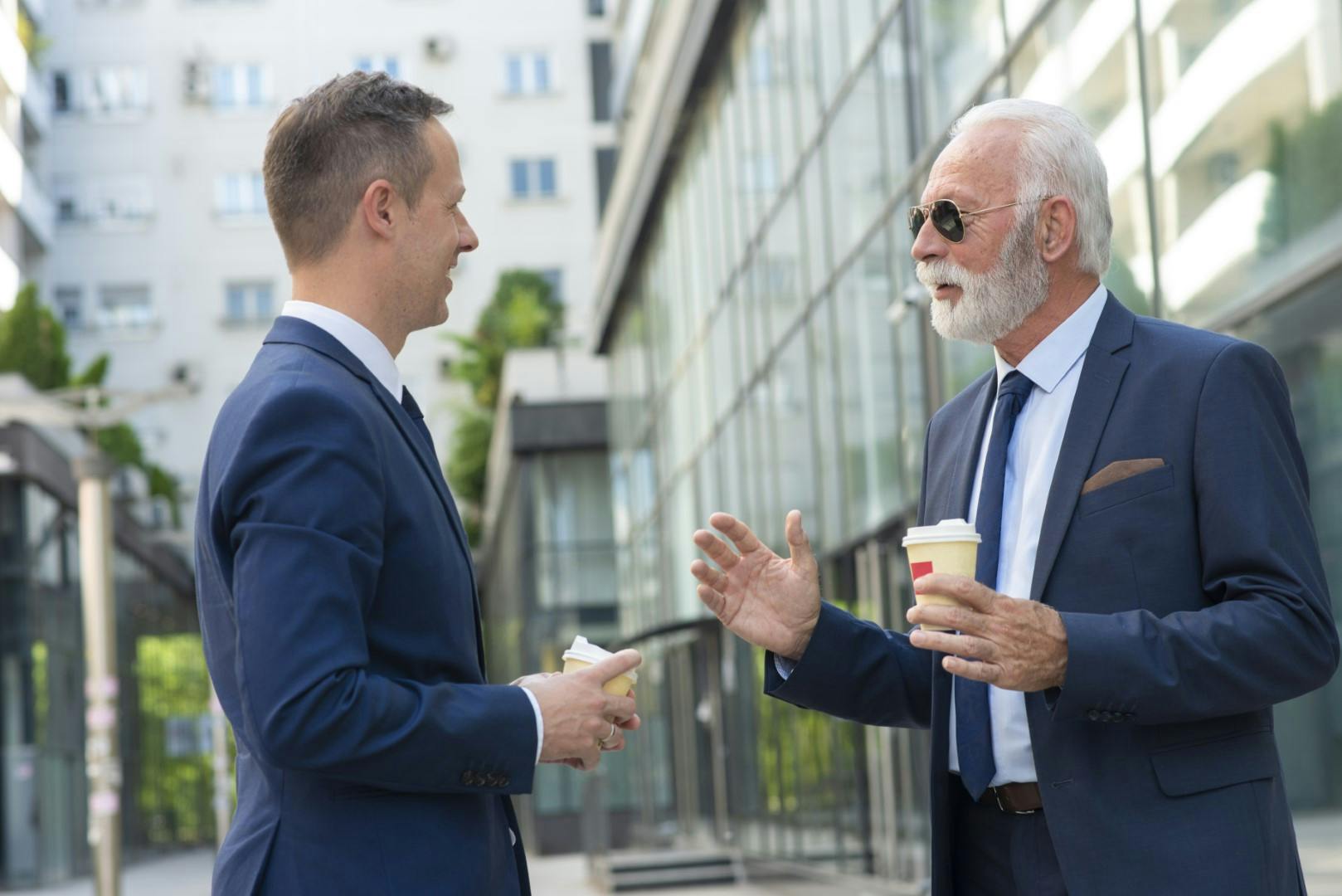 2 men in suits talking outside offices