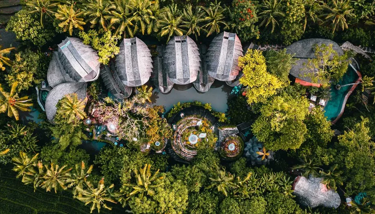 Aerial drone view of luxury eco-resort in Bali nestled within dense tropical jungle
