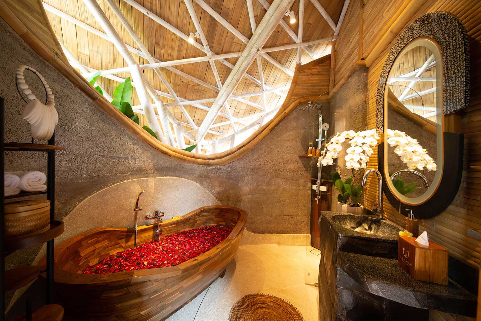 bathroom with bathtub filled with flowers in a one bedroom villa with private pool in eco luxury resort in bali