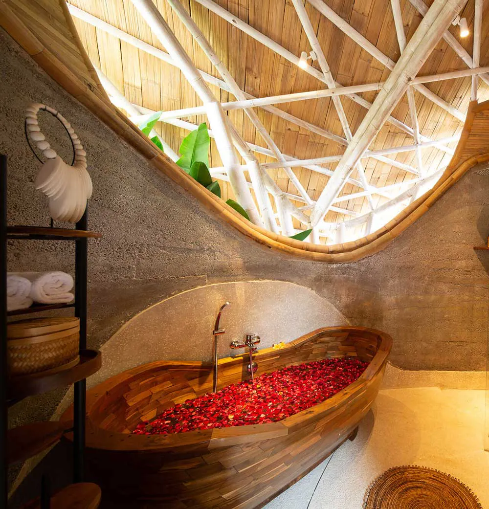 bathroom with bathtub filled with flowers in a one bedroom villa with private pool in eco luxury resort in bali