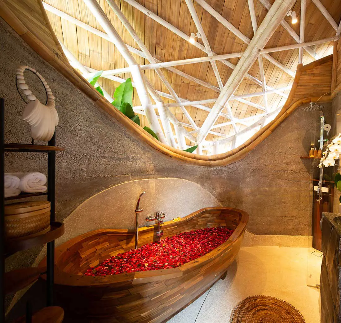 bathroom with bathtub filled with flowers in a one bedroom villa with private pool in eco luxury resort in bali