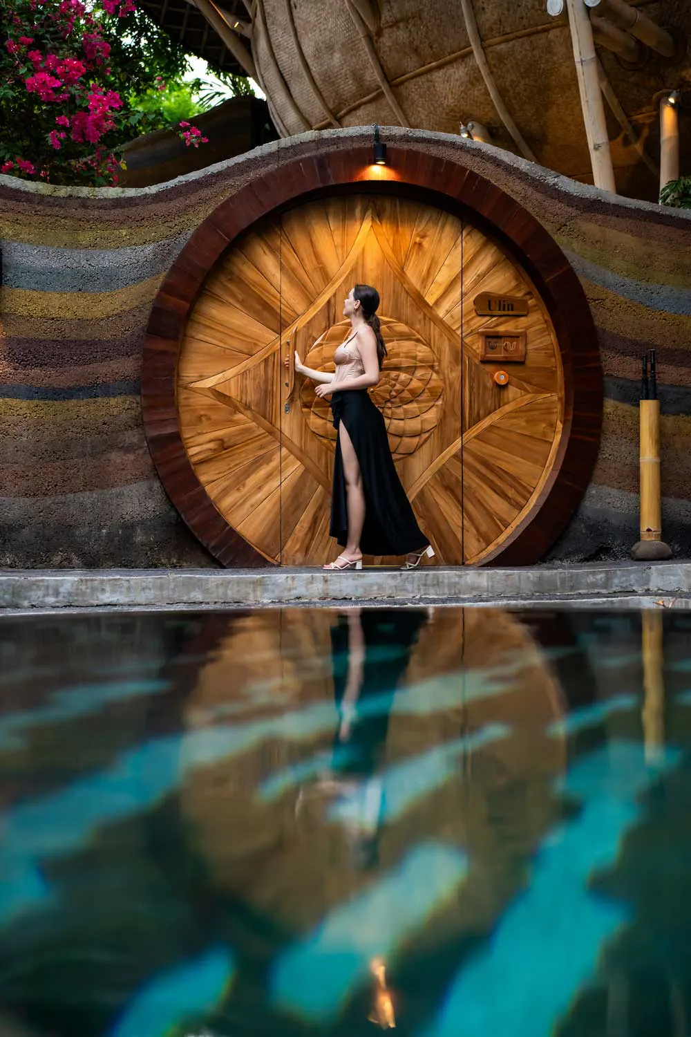 beautiful large wooden door by infinity pool of a eco luxury resort in bali