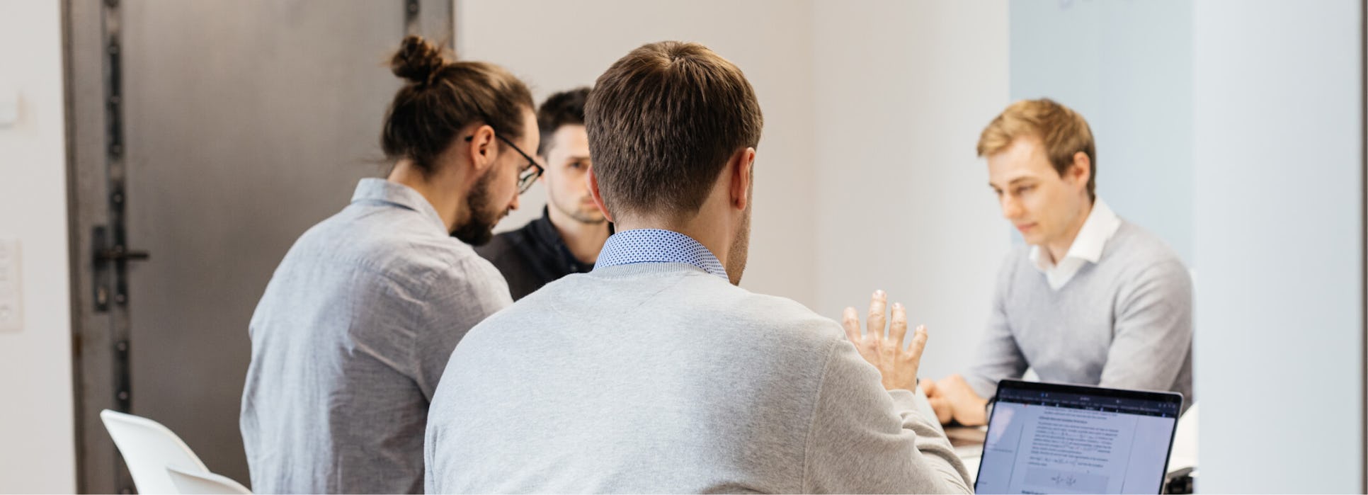 The equity selection team is discussing something during a meeting in the conference room.