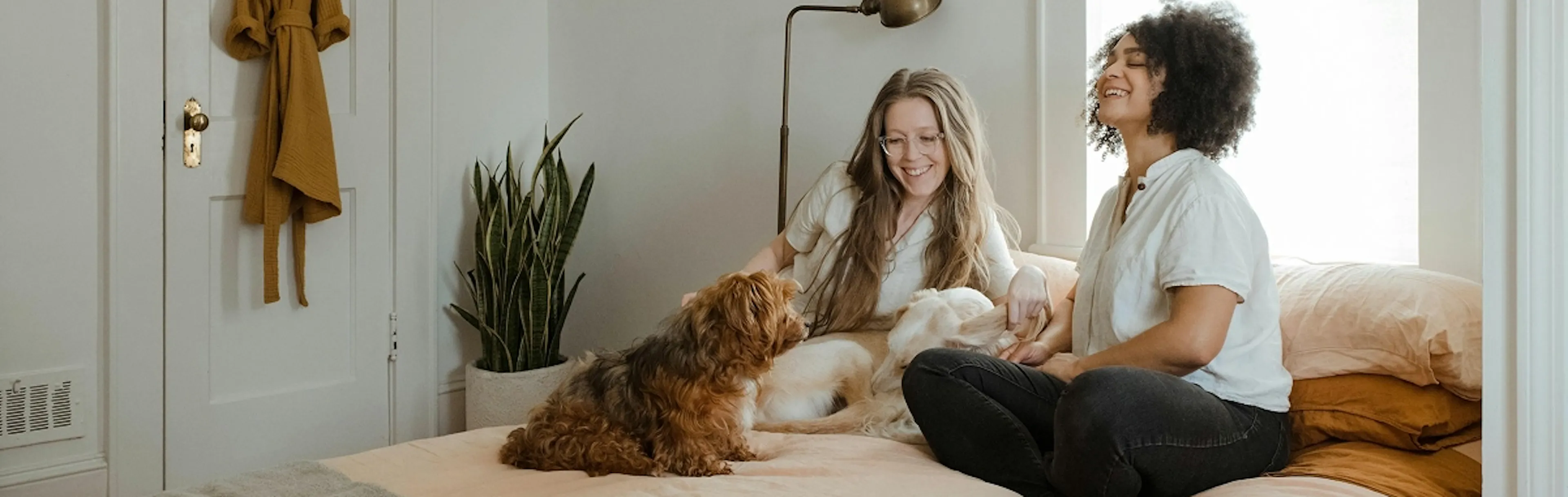 Happy young couple and their dog in their bedroom