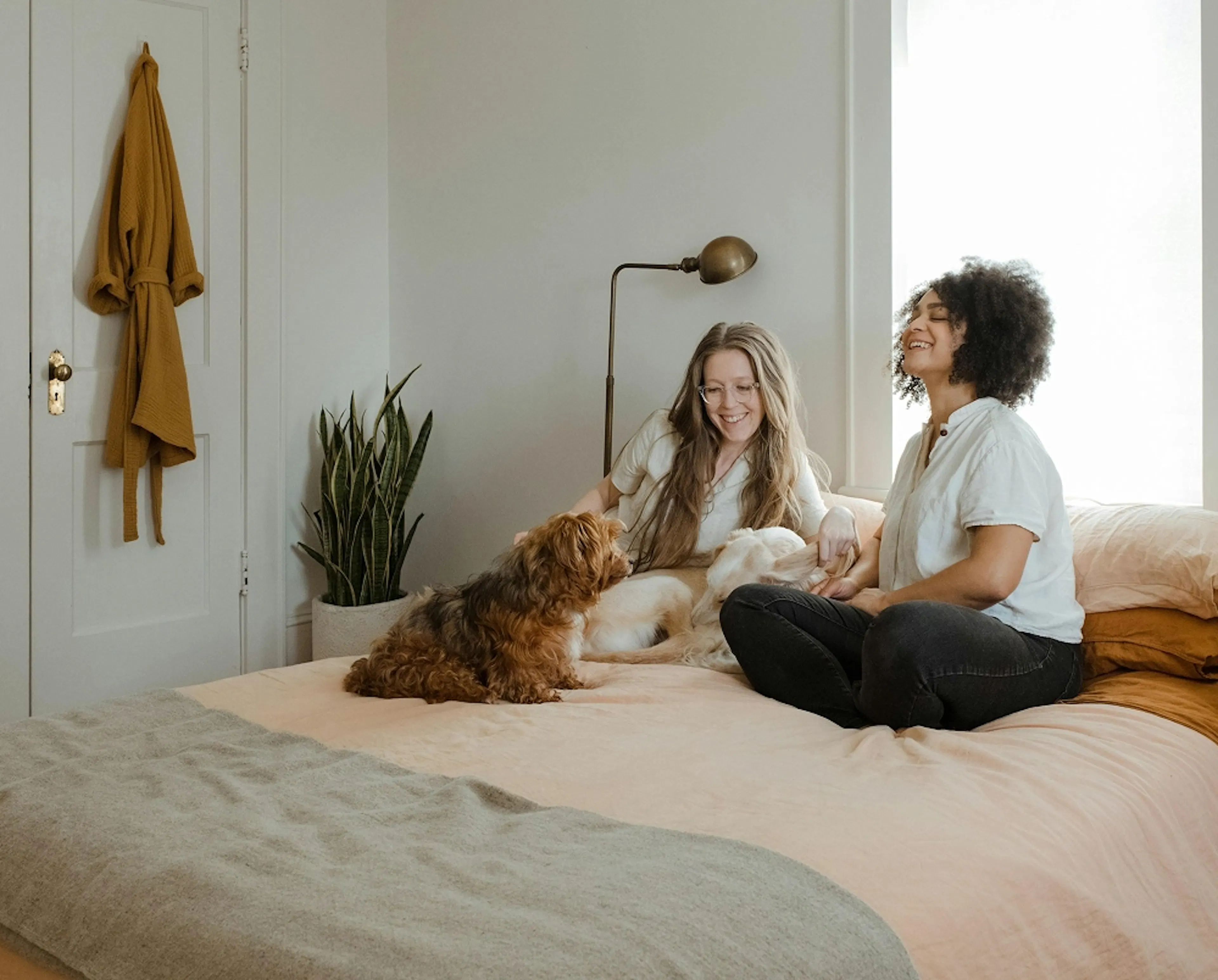 Happy young couple and their dog in their bedroom
