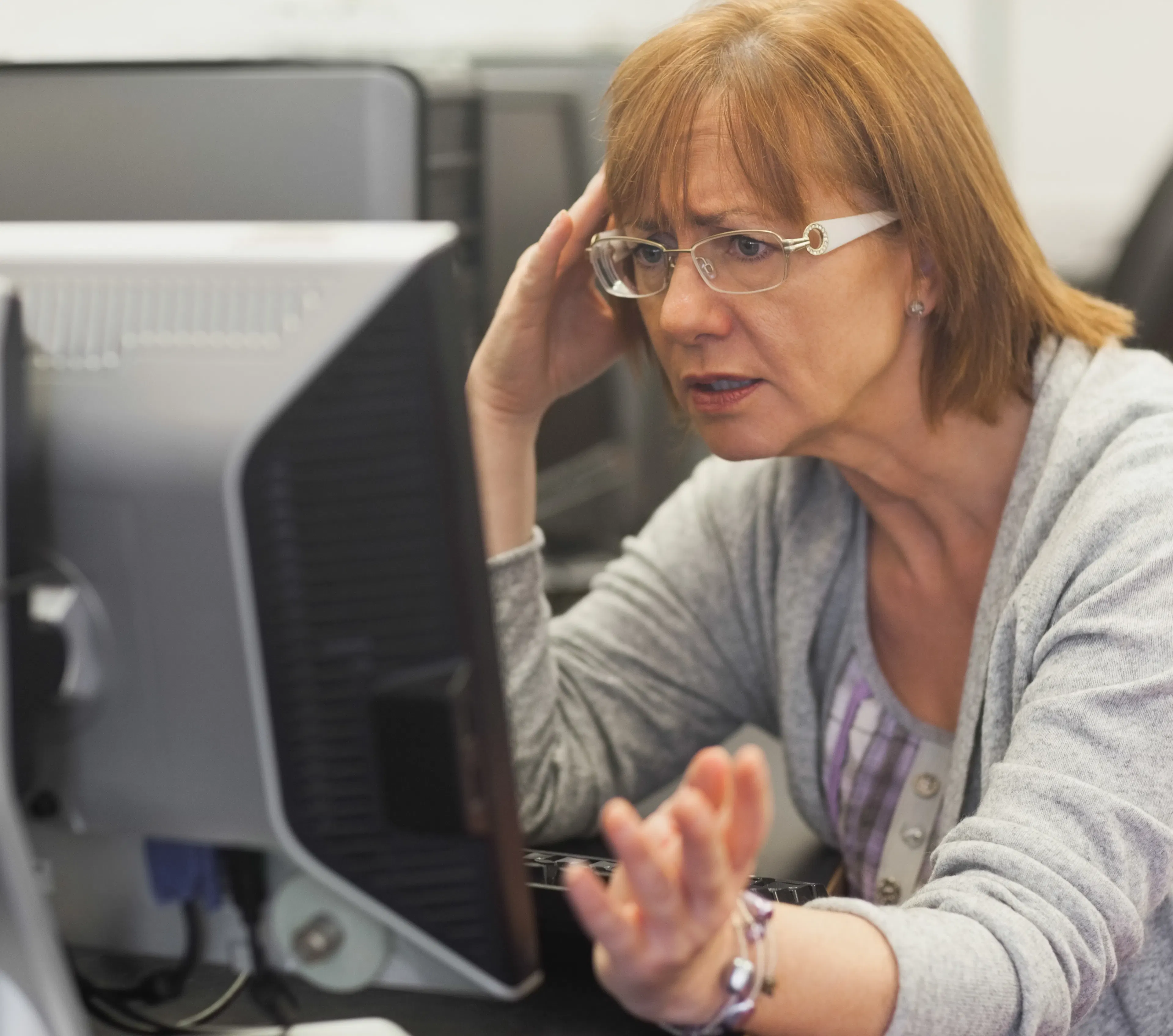 Angry mature woman frustrated in front of a computer