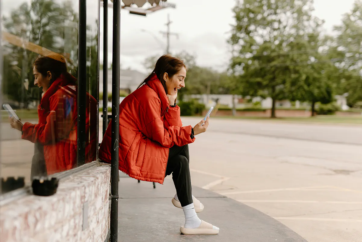 young woman with a very bad credit history, receiving a text message about a car loan approval