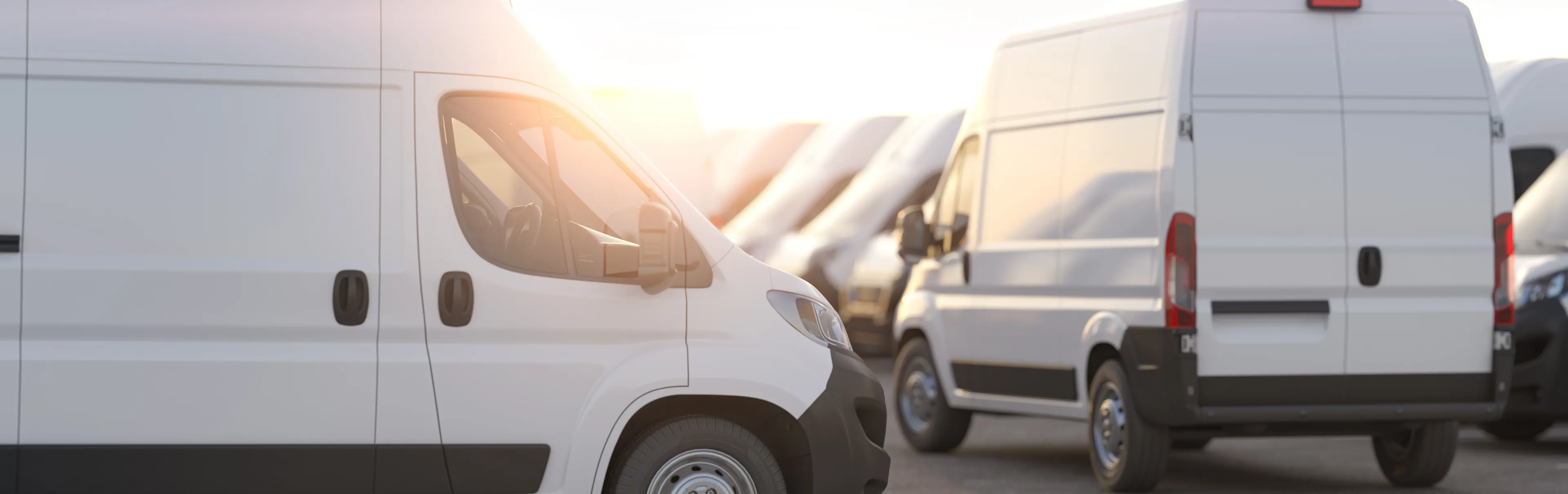Delivery vans in a row in the rays of sunset or dawn