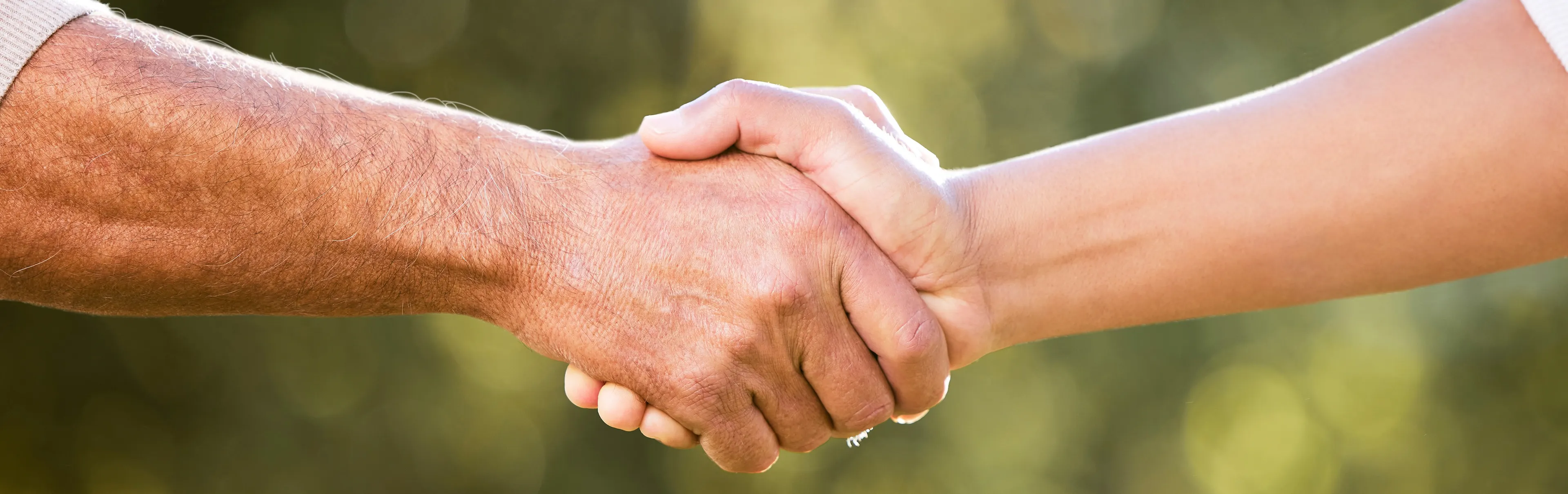 We can do this together. Shot of two unrecognisable men shaking hands outdoors