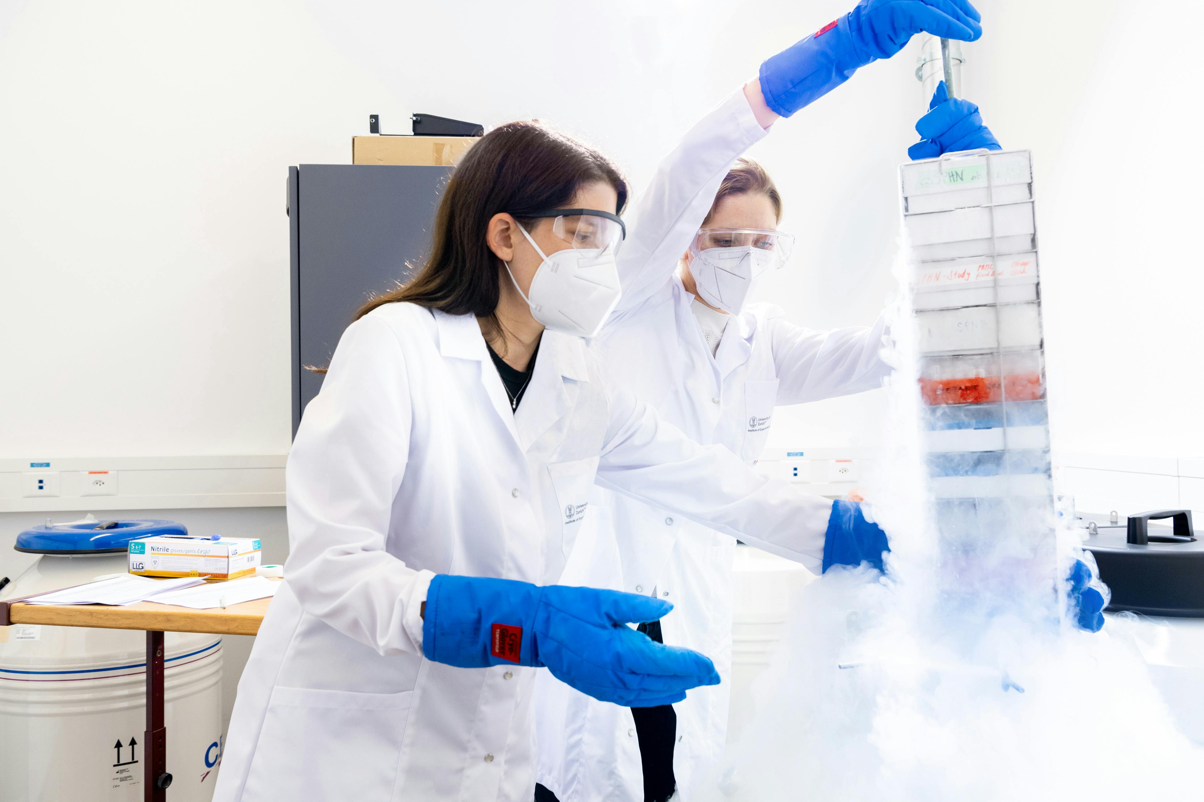 Two researchers take blood samples out of a freezer at a laboratory 