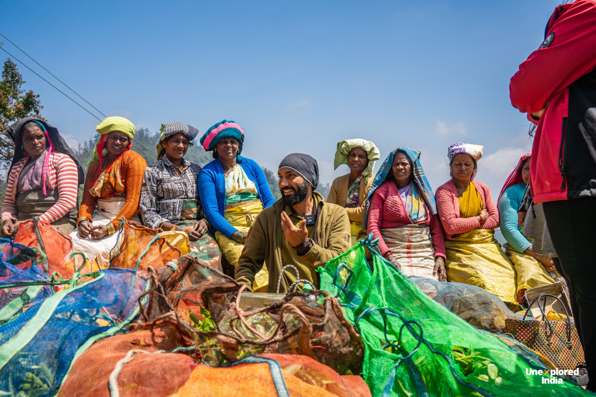 Kurumba tribe women in colourful traditional clothing sit with woven bags during an interaction in the Nilgiris.
