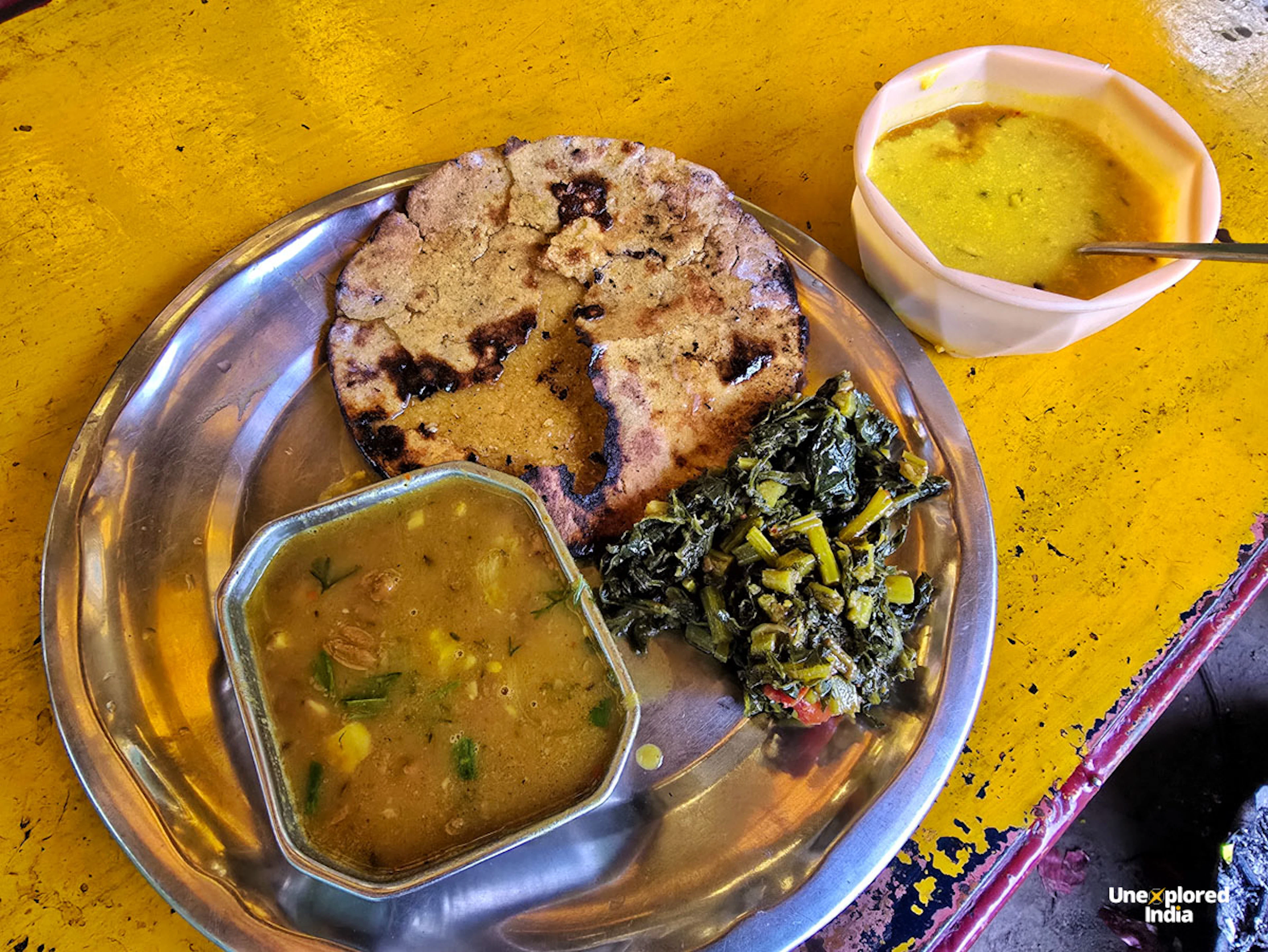 Traditional Kullu food platter with local flatbread, lentil curry and leafy greens in Himachal Pradesh
