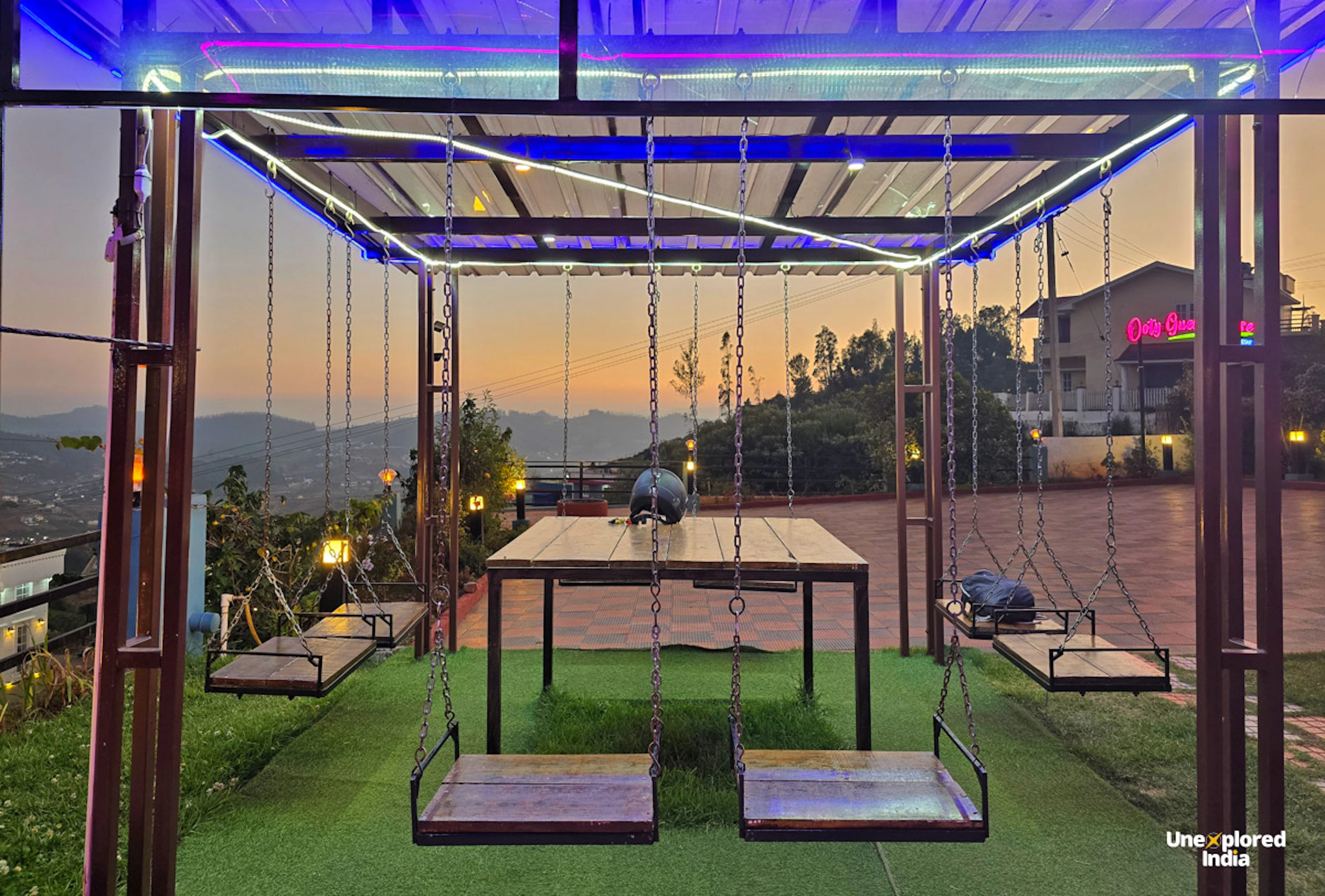 Ooty homestay with outdoor swings and seating overlooking the Nilgiris at sunset.