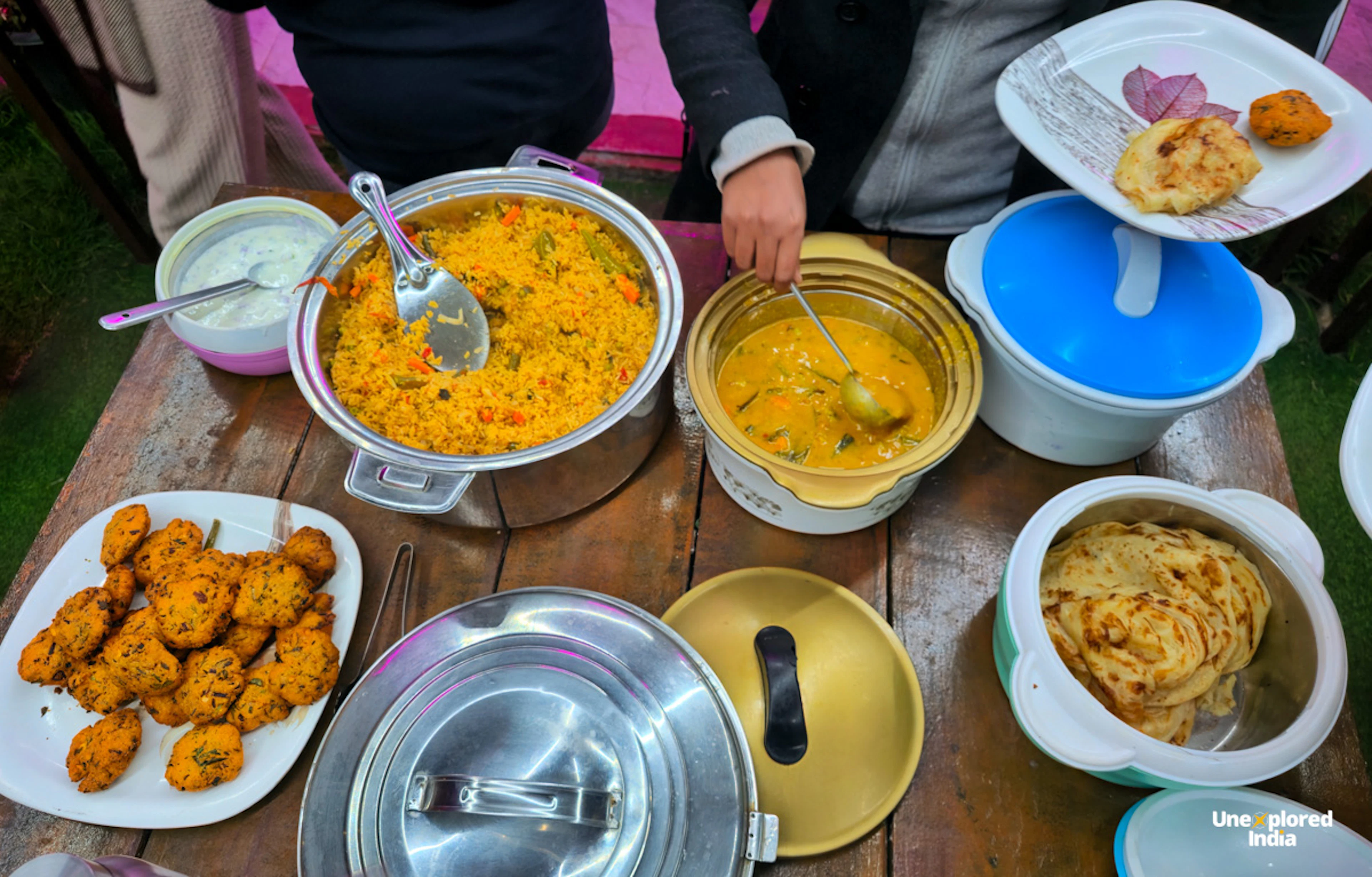Traditional Nilgiris meal with biryani, curry, parotta, curd and savoury fritters served at a local homestay.