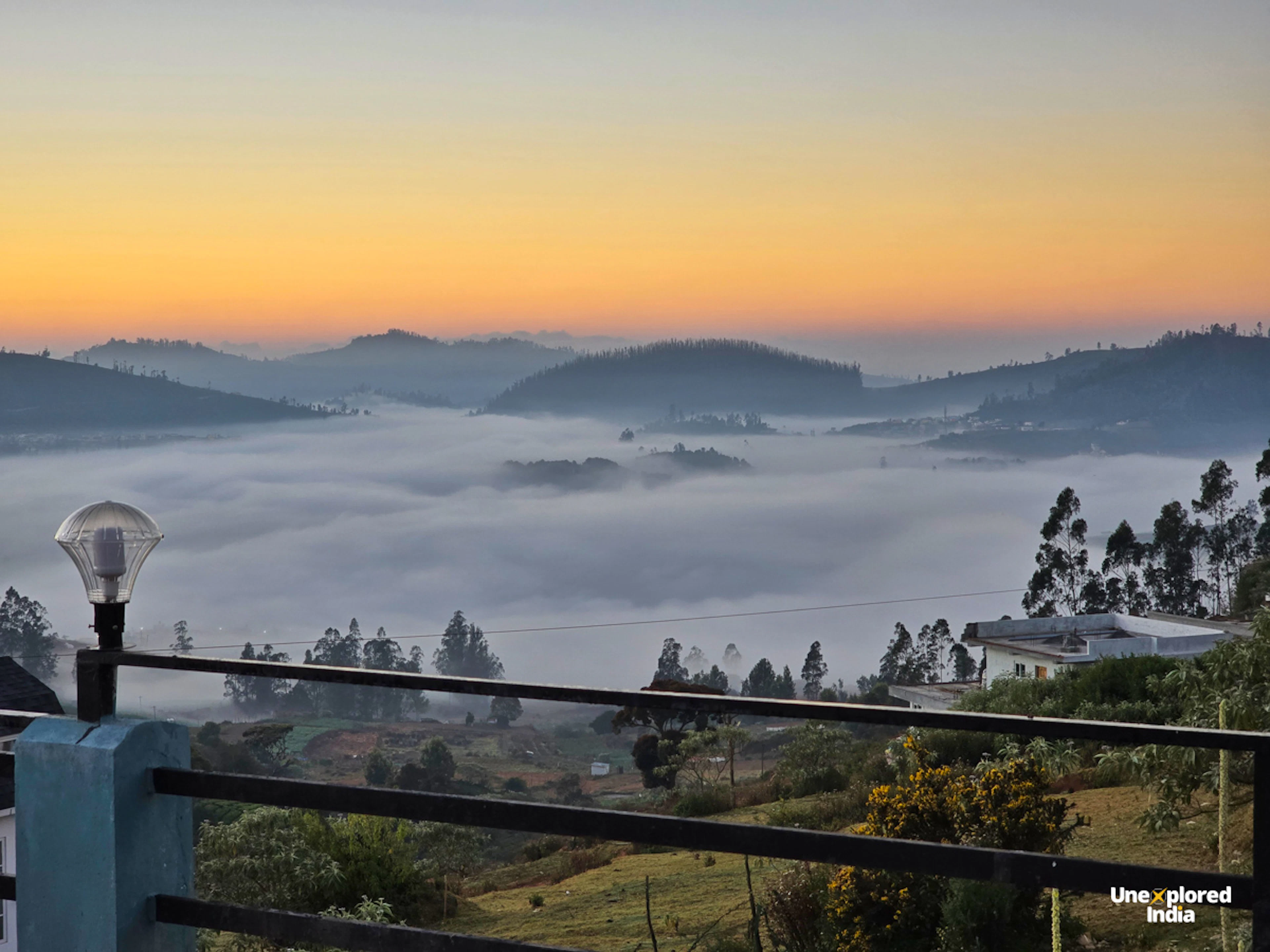 Sunrise over mist-covered hills and valleys viewed from a homestay in Ooty, Nilgiris.