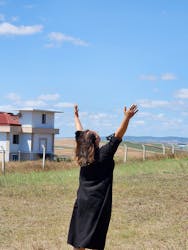 Woman in black dress with hands raised to the sky