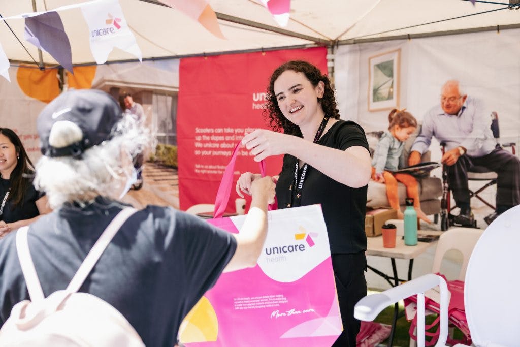 Seniors receive gift bags from the Unicare Health assistive technology display