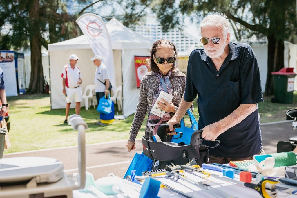 Seniors look at reachers and grabbers in the Unicare Health independent living aid display