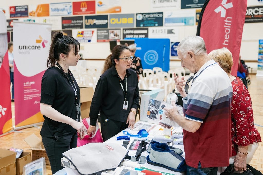 Seniors chat to Unicare Health about assistive technology daily living aids at Rockingham Seniors and Carers Expo 2023