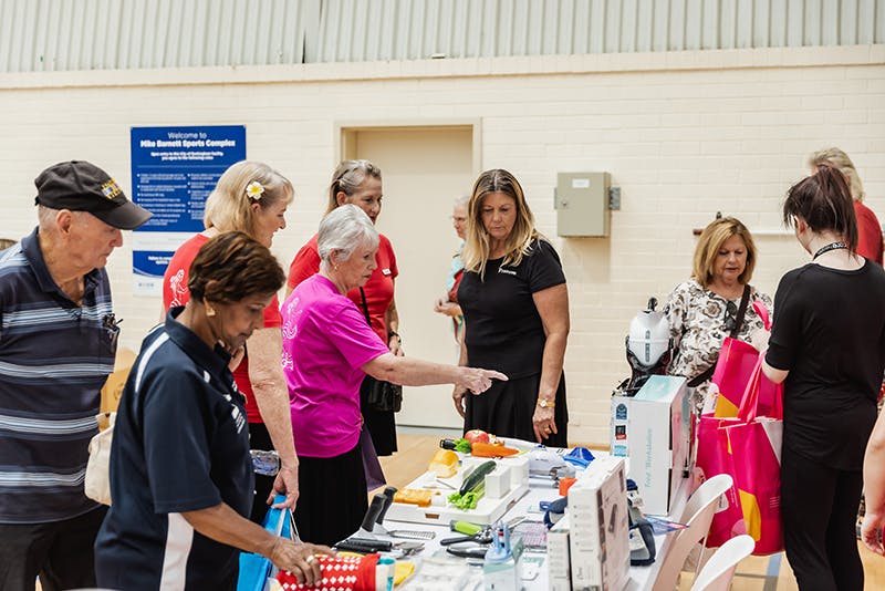 Seniors explore assistive technology aids at Unicare Health's display at Have A Go Day Rockingham 2023