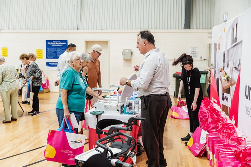 Seniors discuss seat walkers and mobility aids with Unicare Health at Have A Go Day Rockingham 2023