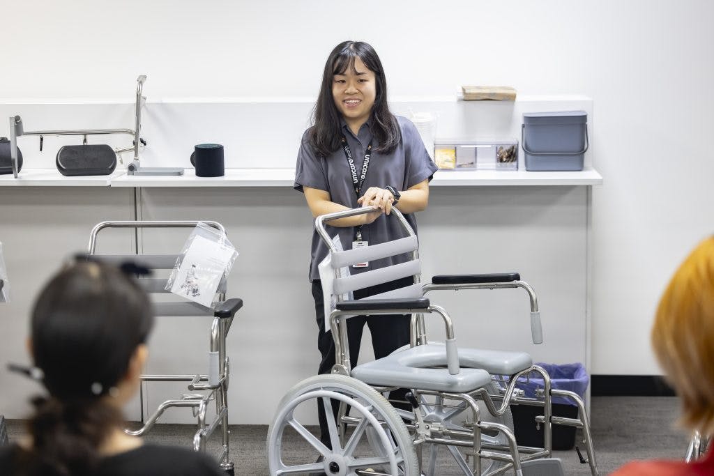 A Unicare Health clinical trainer demonstrates a JUVOCare shower commode at the Unicare Health free masterclass for occupational therapists
