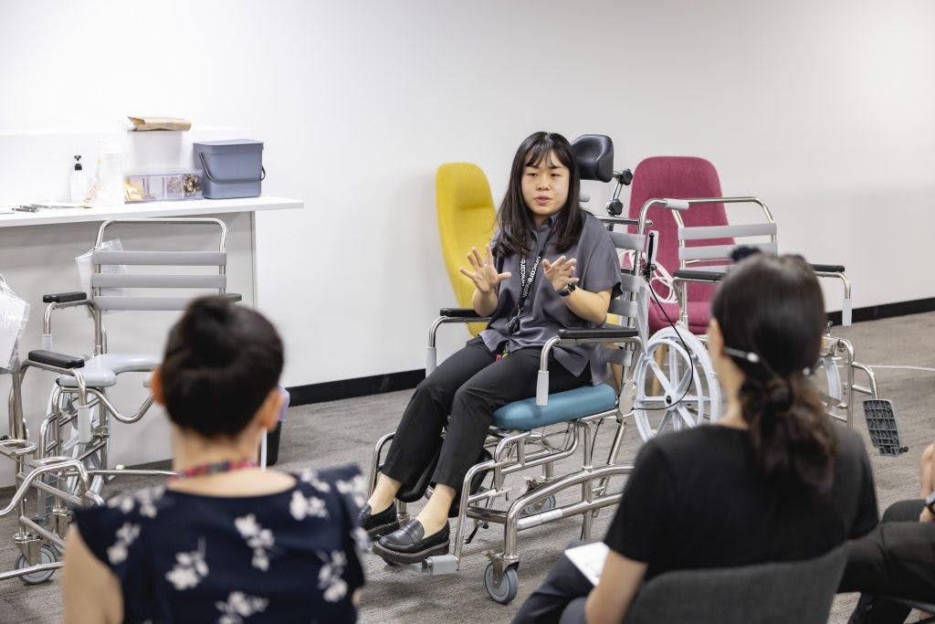 Occupational therapists ask questions about JUVOCare shower commodes to a Unicare Health clinical trainer in the Assistive Technology Collaboration Centre