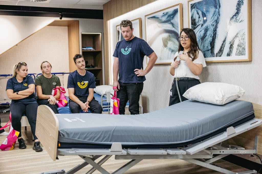 Unicare Health clinical educator Ilissa Liew engages SuperYou student therapists in discussion about electric profiling nursing care beds and pressure care mattresses