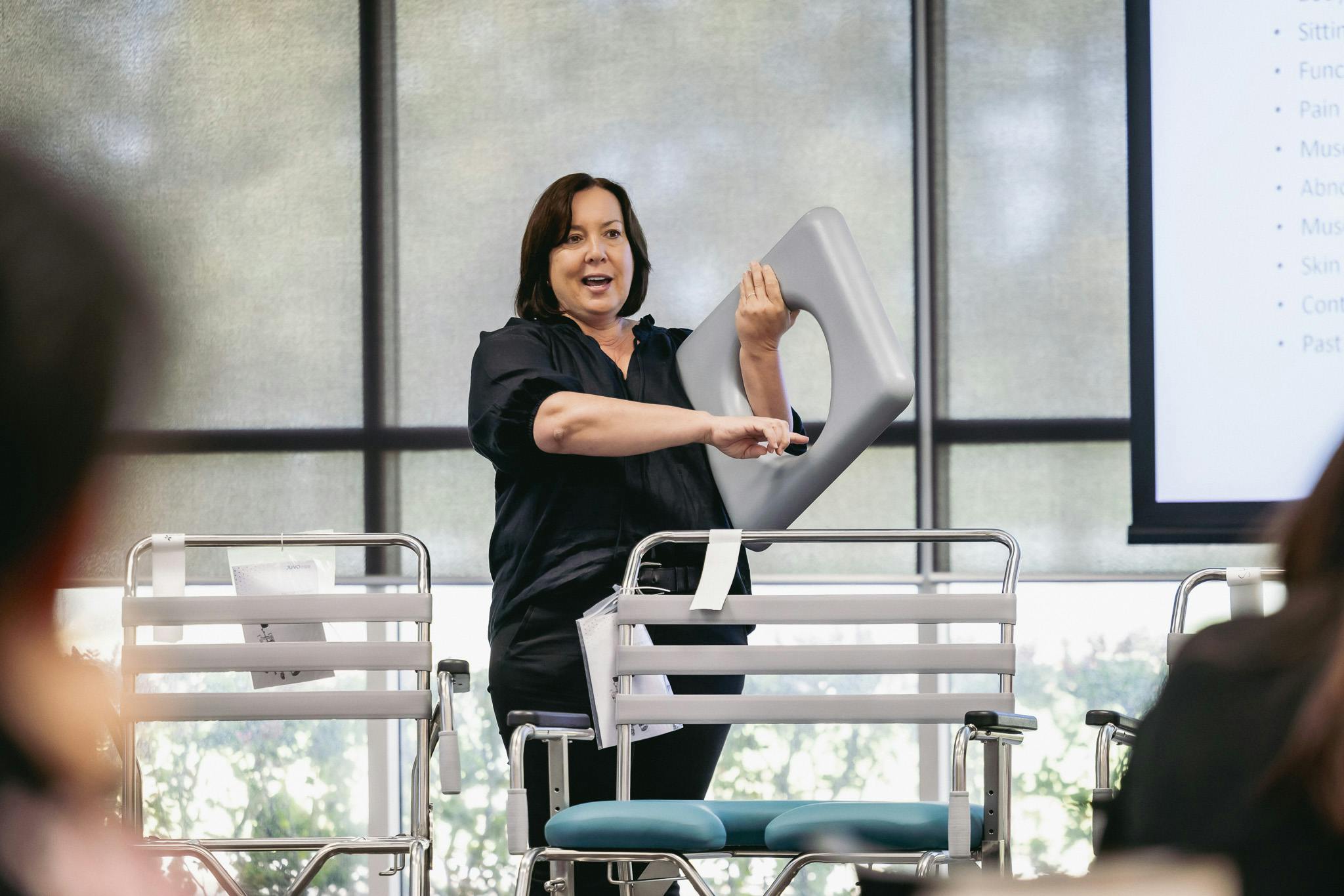 clinical educator demonstrates shower commode seating solutions