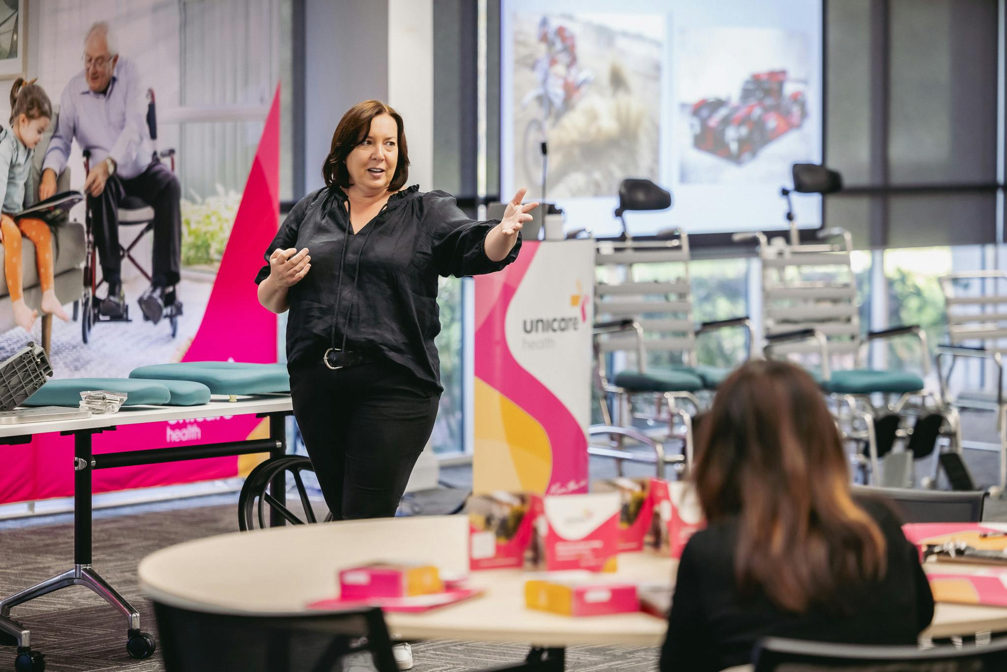 Occupational therapists listen to clinical educator discuss shower commode prescription