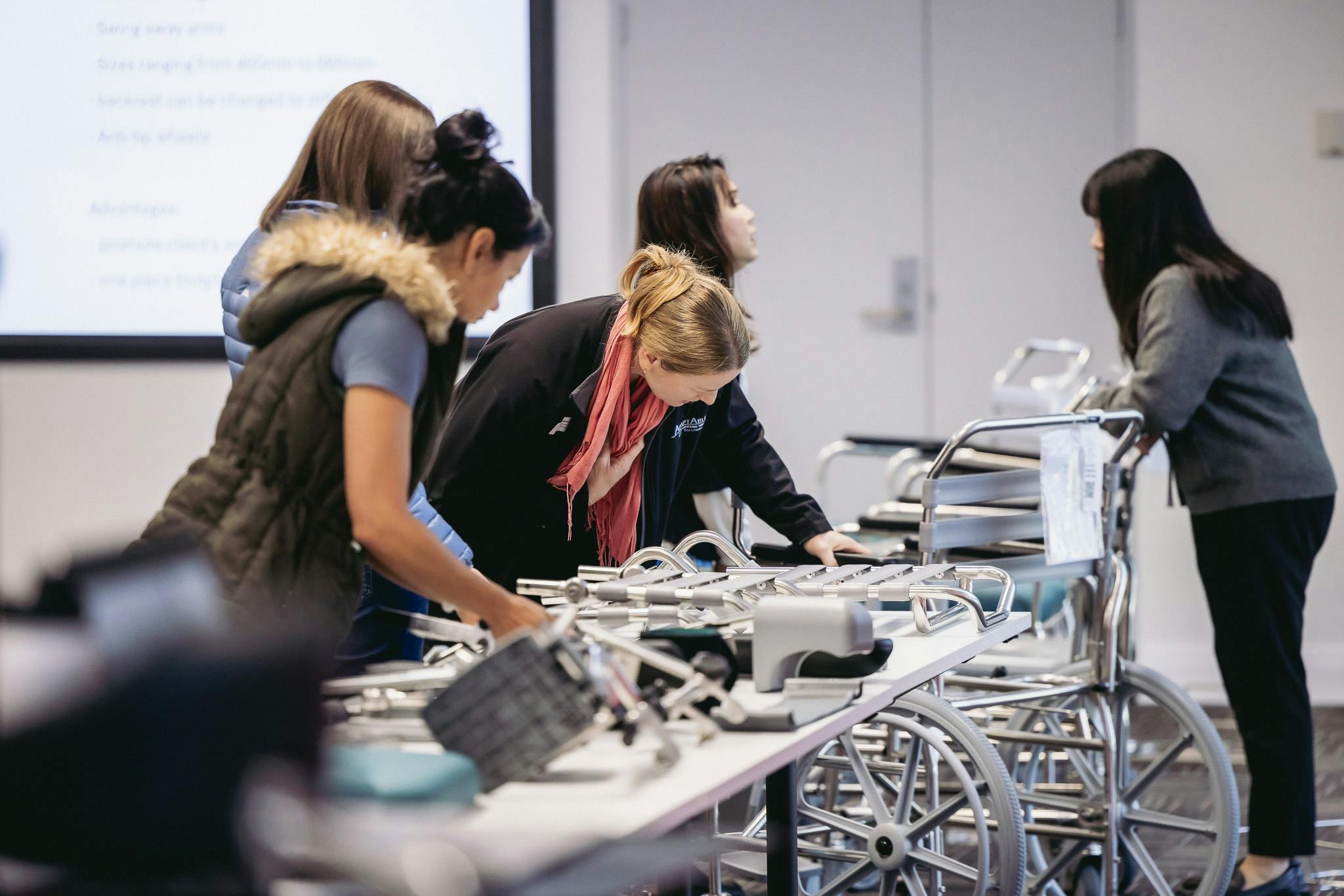 occupational therapists examine a table of shower commode accessories