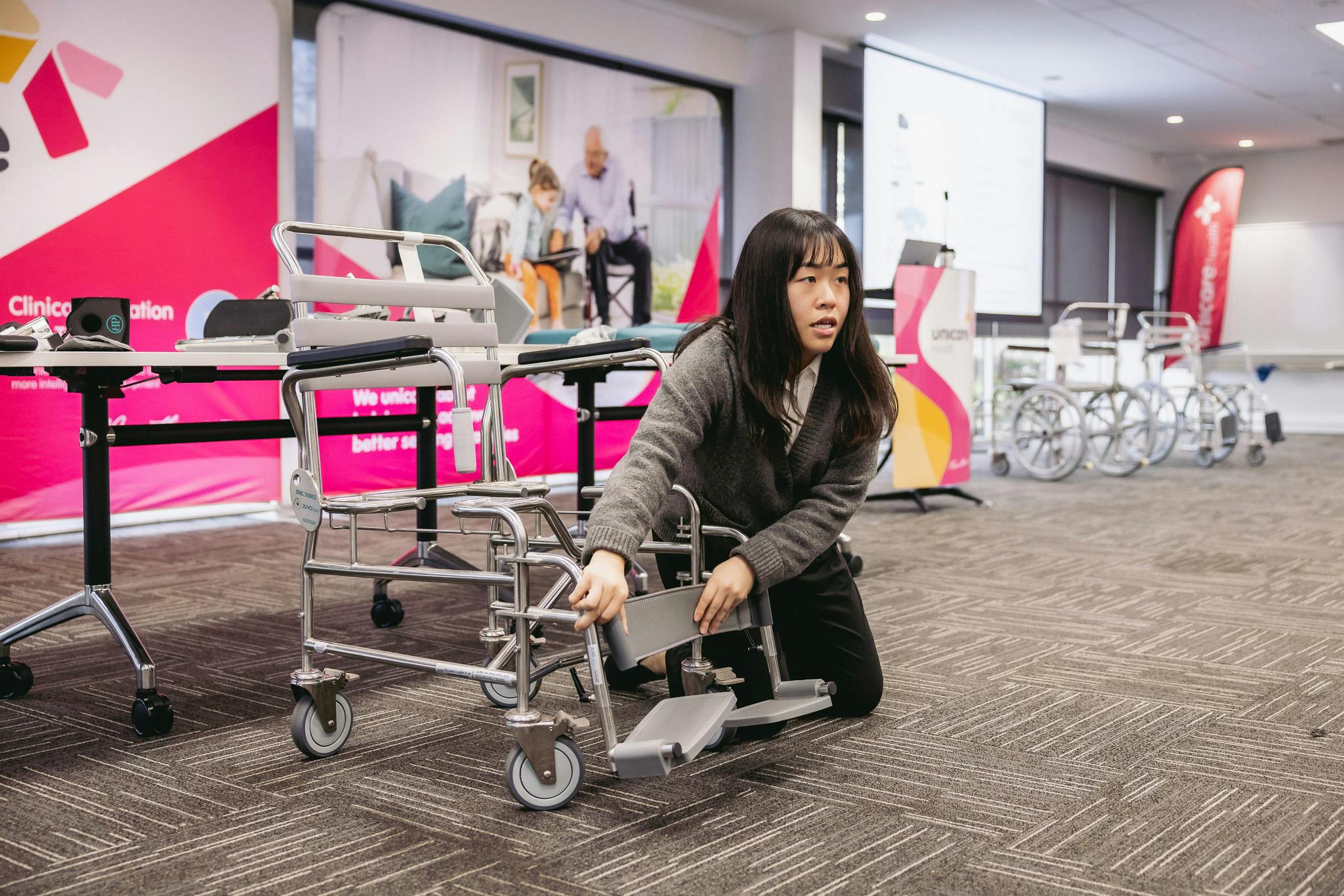 clinical educator demonstrates shower commode leg support straps