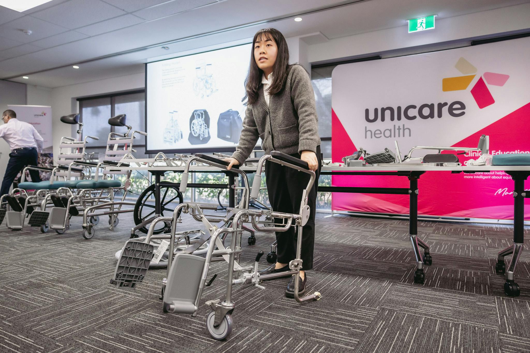 clinical educator demonstrates a folding shower commode