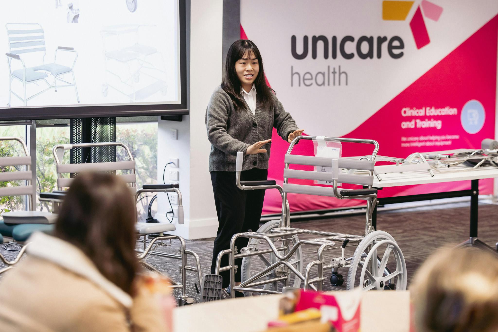 clinical educator explains swing-away armrests on JUVO shower commodes