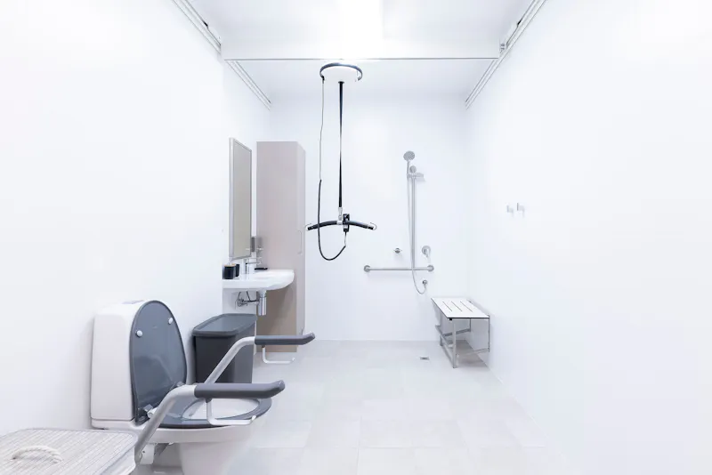 Fully accessible bathroom with ceiling hoist, shower bench and support rails at Lady Lawley Cottage Cottesloe, Perth disability accommodation